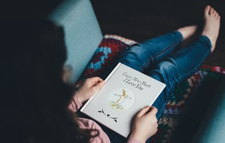 a child holding a book on the lap