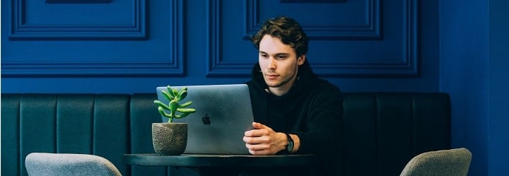 person sitting at a table with a laptop