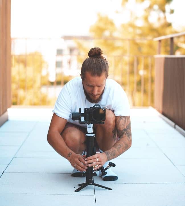 a photographer with a small tripod and dslr camera