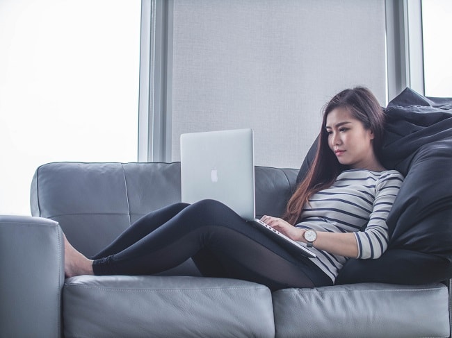 girl on a couch using a laptop computer