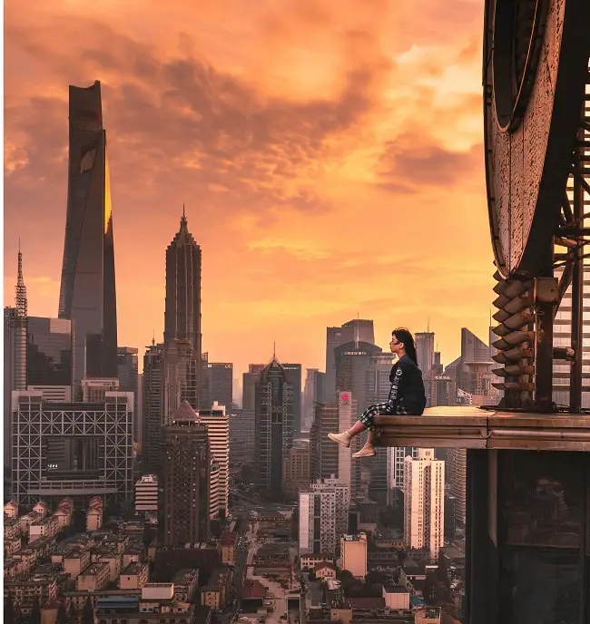 girl sitting up high on a building