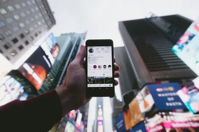 person holding a phone with a social media app-min