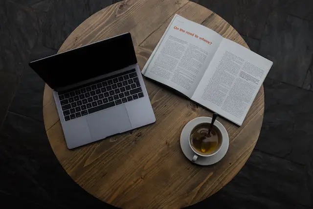 A reading table with a laptop and a print magazine