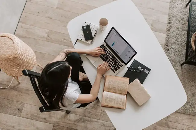 reviewing a book on a laptop