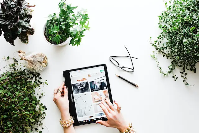 Writing on a tablet surrounded by plants