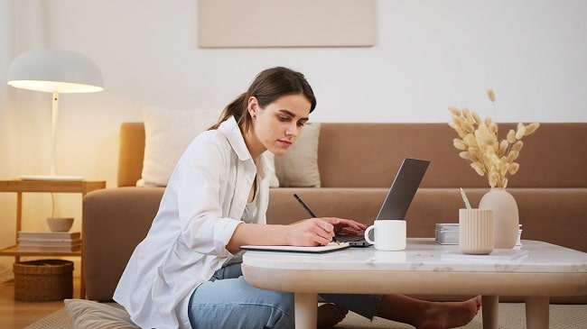 woman doing editing work with a laptop and notebook