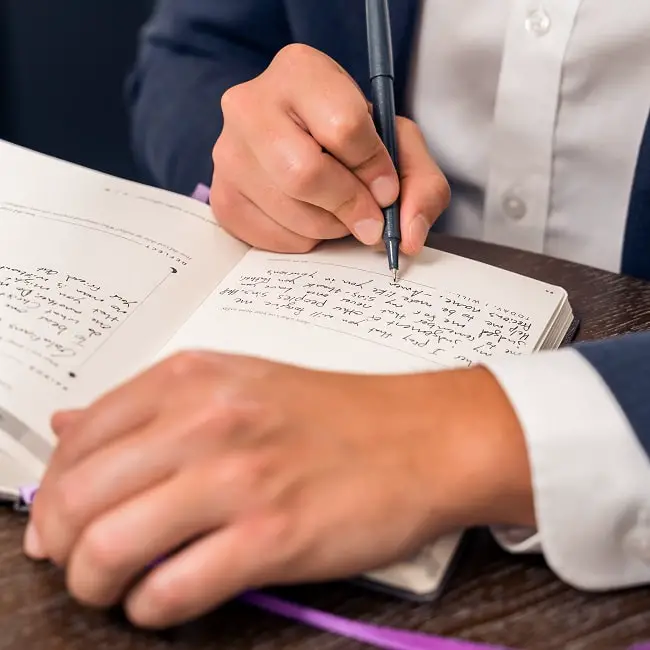 a young man writing an essay in a notebook