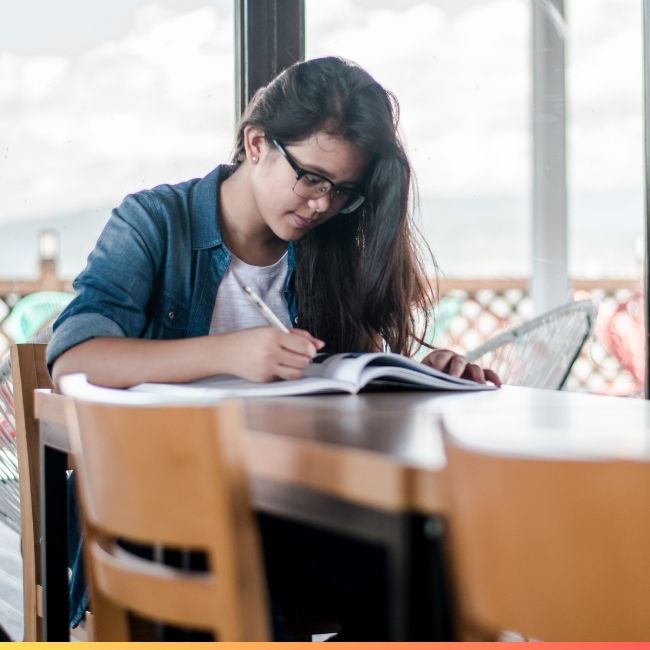 young student writing in a notebook