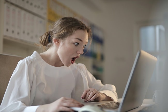young woman shocked looking at screen