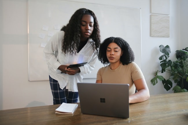 two women with a laptop happy