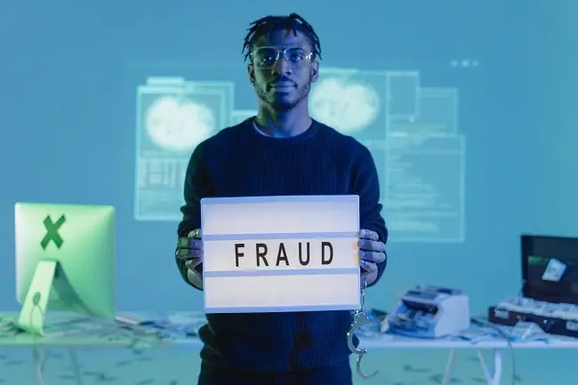 man holding fraud sign