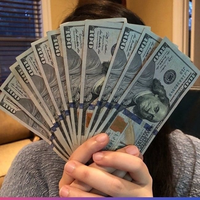 holding hundred dollar bills