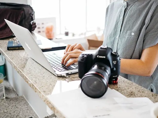 photojournalist typing on computer