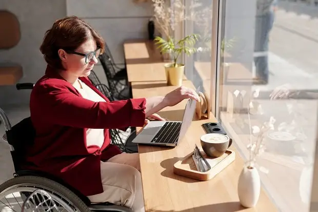 woman on wheelchair using a laptop