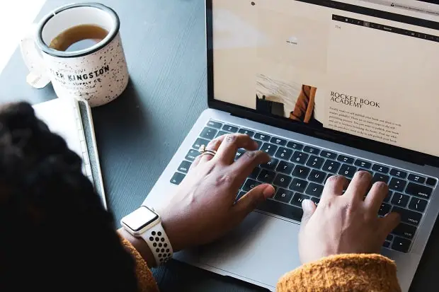 girl writing on a laptop