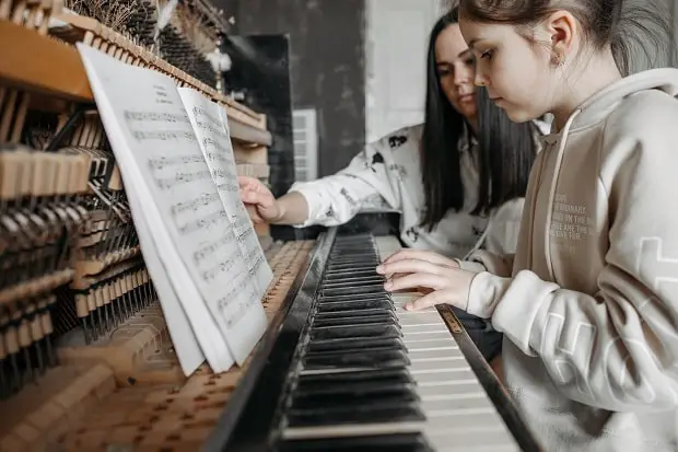 child taking piano lesson