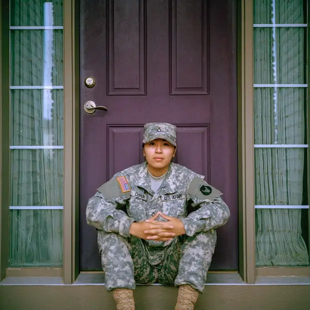 young soldier sitting in front of a door