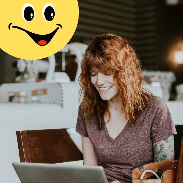 humorous writing - woman laughing while watching something on her laptop
