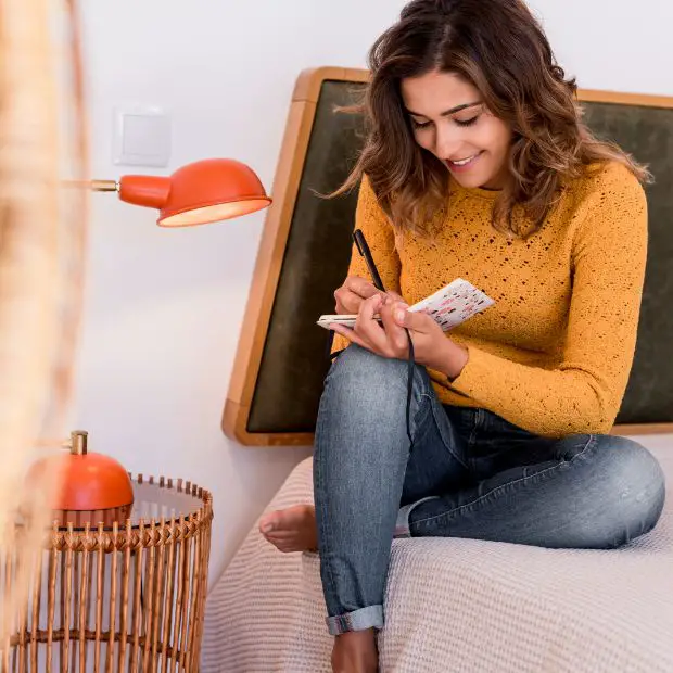 woman writing in a small journal