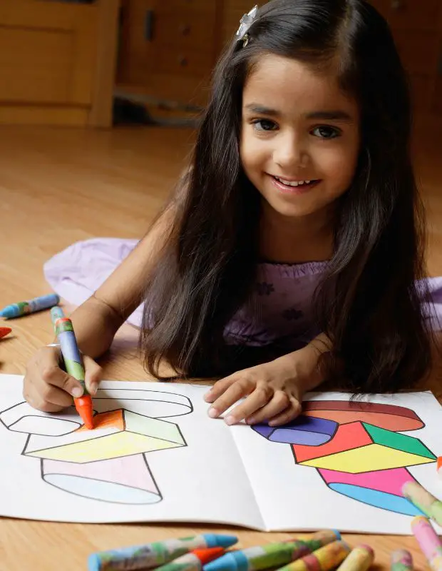 A little girl drawing in a coloring book