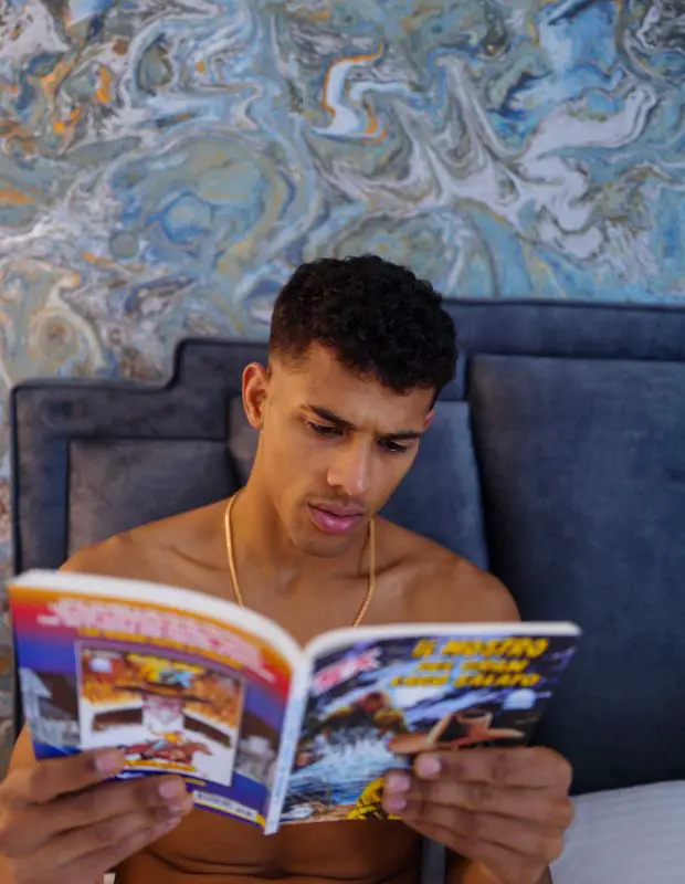 a handsome young man reading a comic book