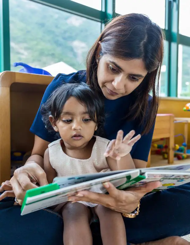 a mom and child reading a board book together