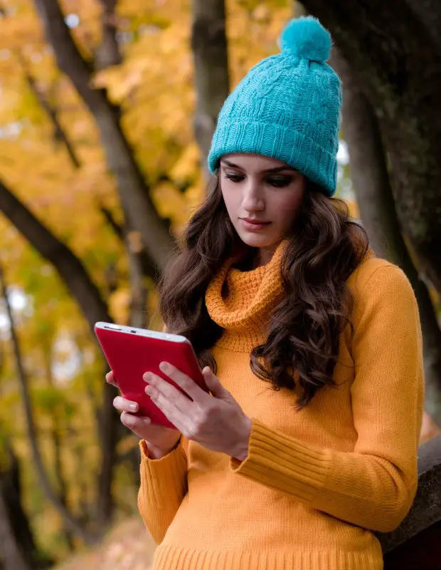 a beautiful girl reading an ebook on a mobile device