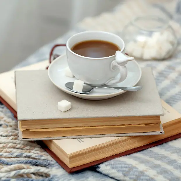 a stack of books and a coffee mug