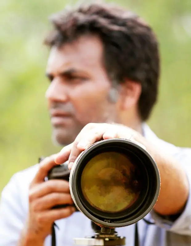 male photographer holding a camera