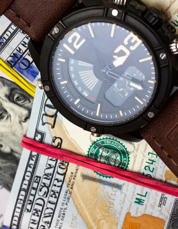 a watch next to dollars